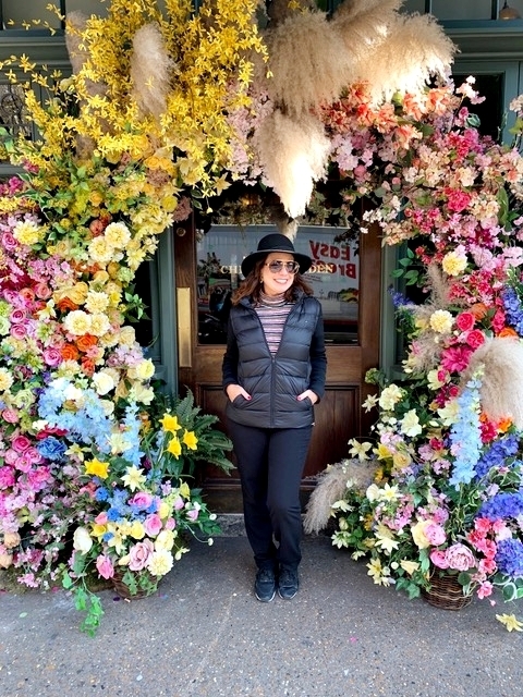mulher na frente de um restaurante todo florido