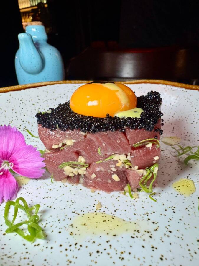 Tartare de atum em cubos temperado e finalizado com ovas negras e gema caipira