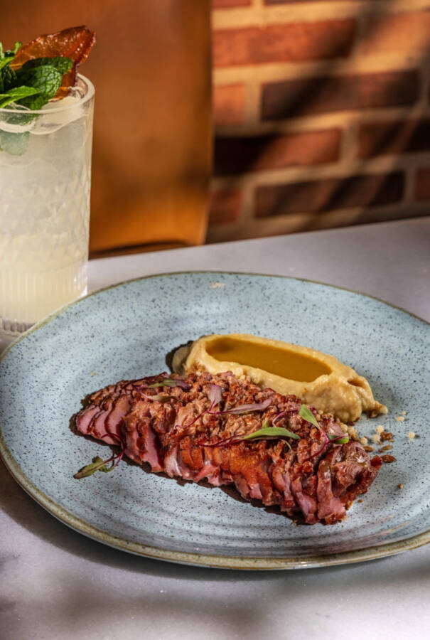 Um prato assado e glaceado em um jus de tucupi, escoltado por musseline de batata doce finalizado com óleo de gergelim e um crumble salgado de granola e cereais