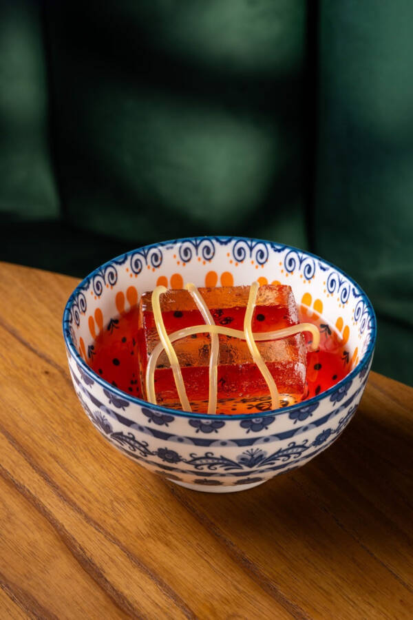 Ramen Negroni é um drink com Campari infusionado com missô e um “espaguete” de laranja e gengibre